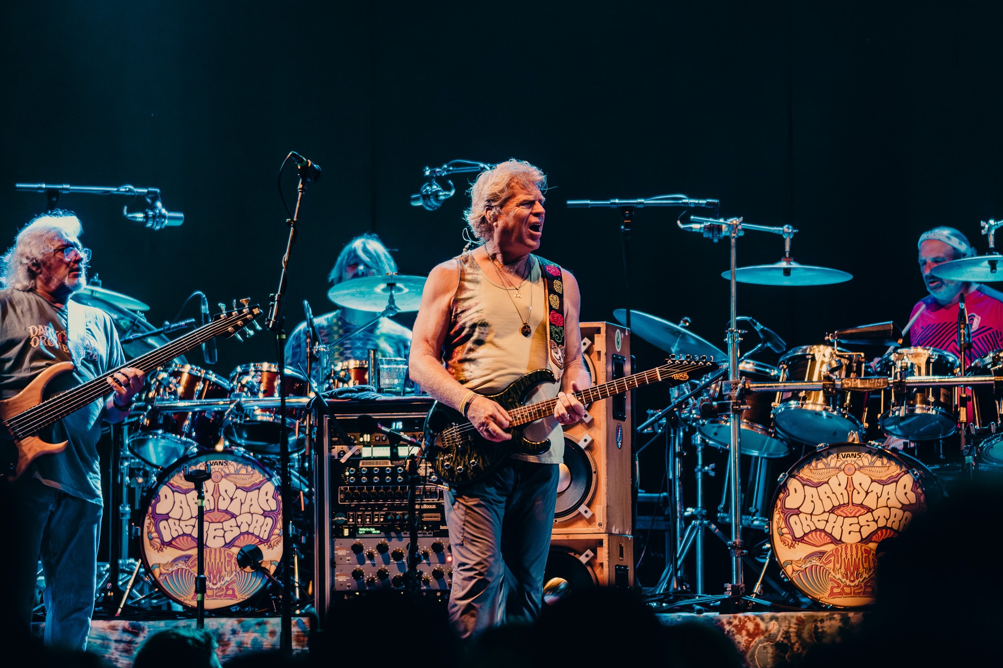 Guitarist performing on stage with full band and Dark Star Orchestra drum kit visible