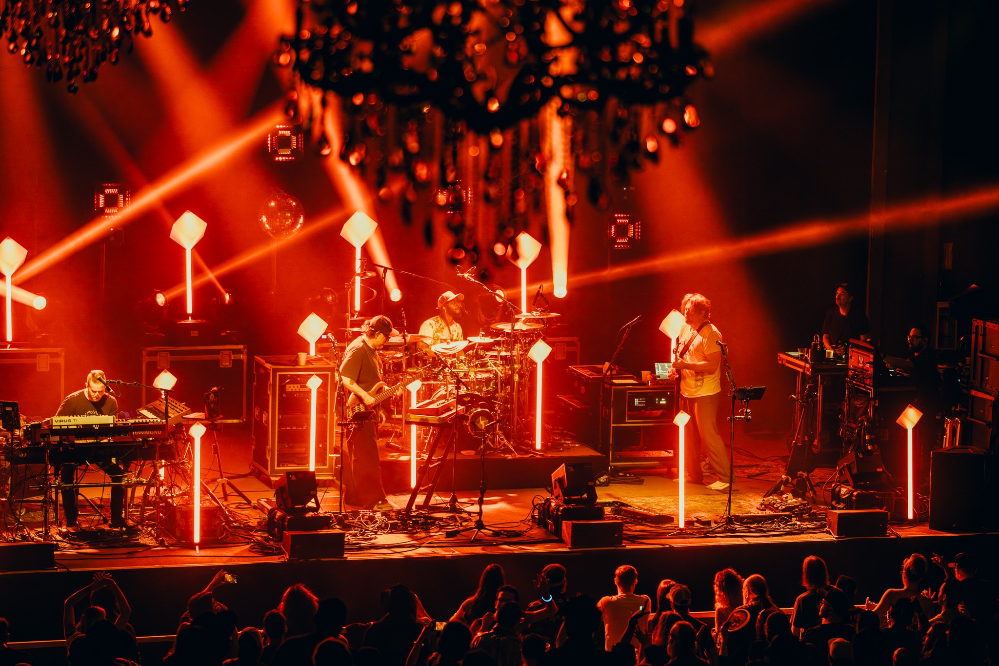 Band performing on stage with red lighting
