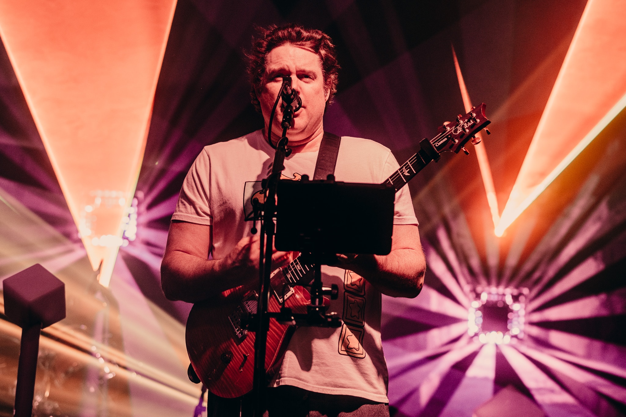 Musician performing on stage with guitar