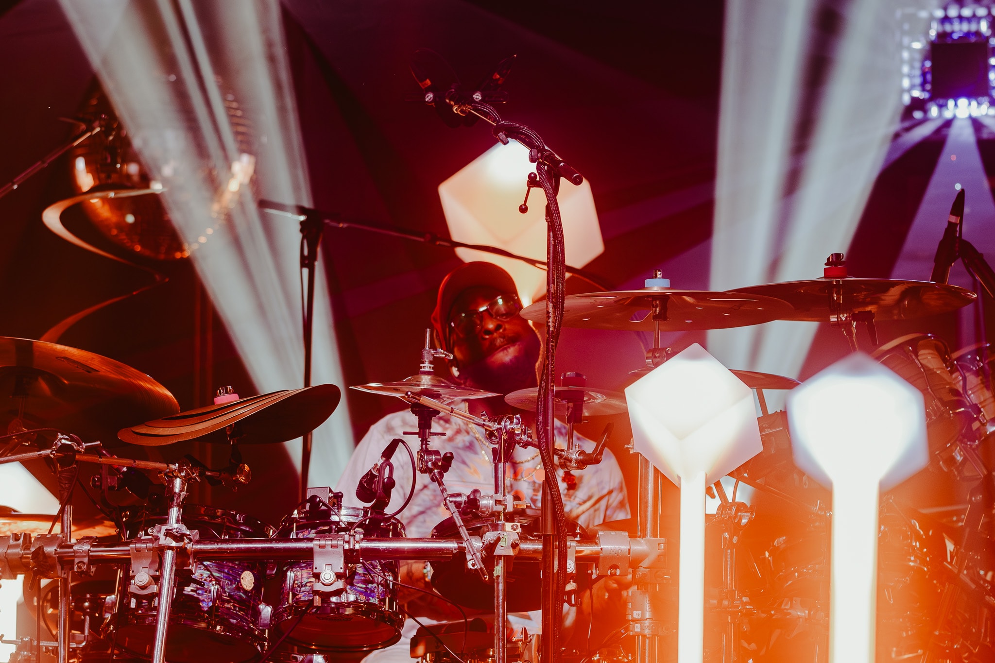 Drummer performing on stage with lights