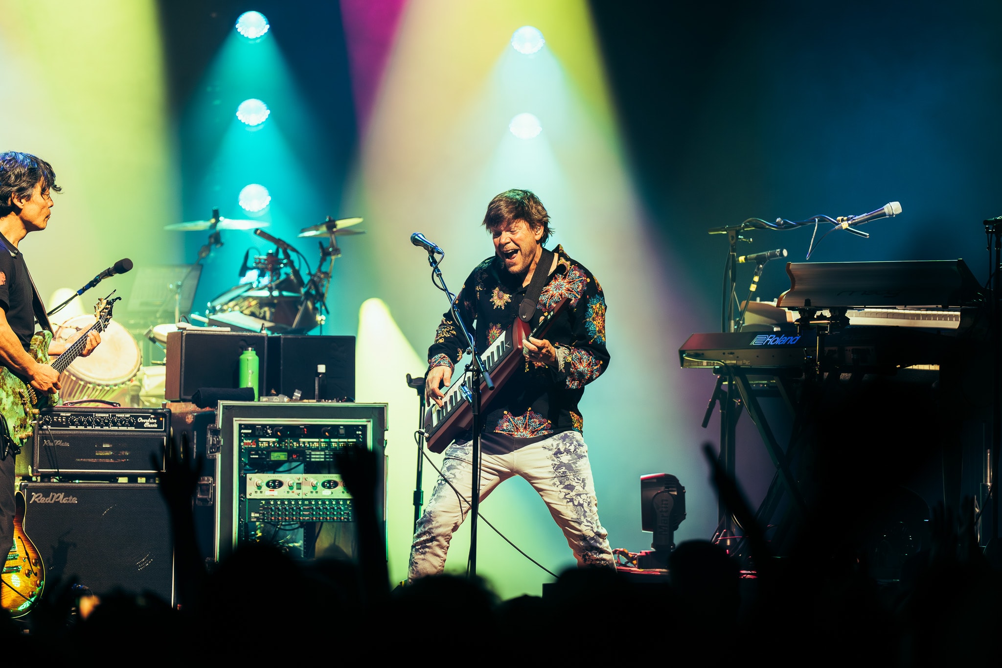 Keytar player performing with colorful green and pink stage lighting