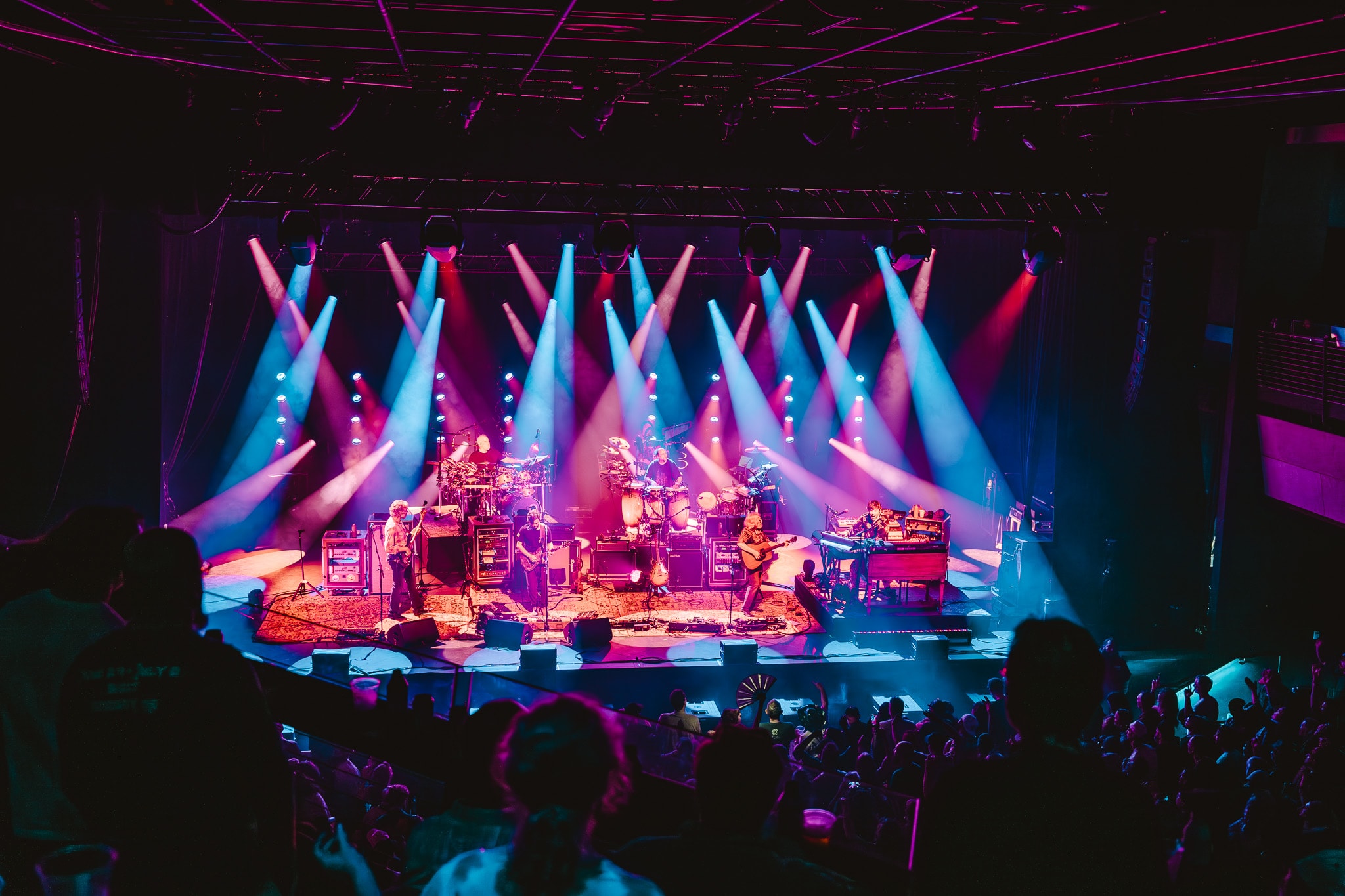 Full band on stage with blue and pink stage lighting